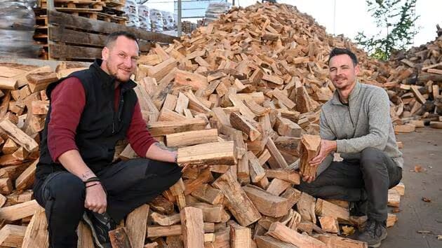 Jean-Paul et Julien devant leur stock de bûches
